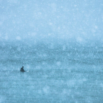 Surfeur sous la neige dans les iles Lofoten